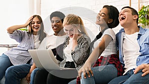 Group of Young Friends Laughing and Sharing Content on Laptop