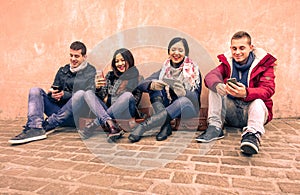 Group of young friends looking their smartphones in old town