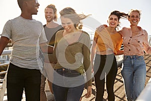 Group Of Young Friends Outdoors Walking Along Gangway Together photo