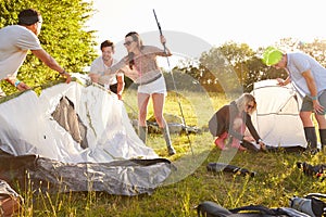 Group Of Young Friends Pitching Tents On Camping Holiday