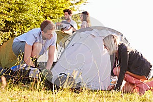 Group Of Young Friends Pitching Tents On Camping Holiday