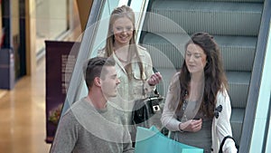 Group Of Young Friends Riding Escaltor In Shopping Mall