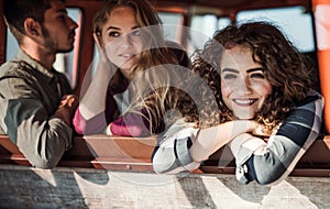 A group of young friends on a roadtrip through countryside, looking out of window.