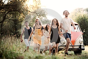 A group of young friends on a roadtrip through countryside, running.