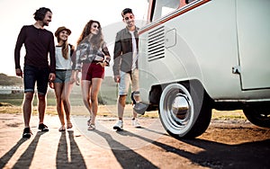 A group of young friends on a roadtrip through countryside, walking.