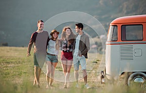 A group of young friends on a roadtrip through countryside, walking.