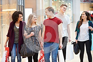 Group Of Young Friends Shopping In Mall Together