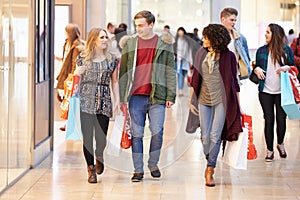 Group Of Young Friends Shopping In Mall Together