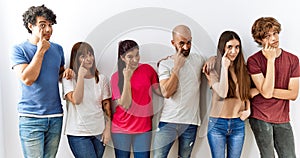 Group of young friends standing together over isolated background pointing to the eye watching you gesture, suspicious expression