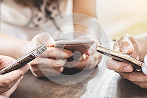 Group of young friends using smart phone in a coffee shop,