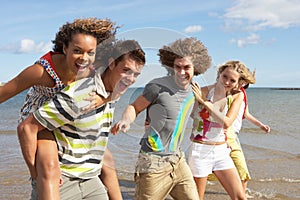 Group Of Young Friends Walking Along Shoreline