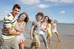 Group Of Young Friends Walking Along Shoreline