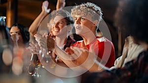 Group of Young Friends Watching a Live Soccer Match on TV in a Sports Bar. Excited Fans Cheering and