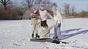 Group of young friends wears ice skates have fun on frozen lake