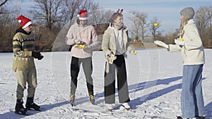 Group of young friends wears ice skates have fun on frozen lake