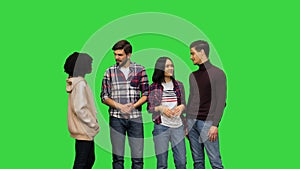 A group of young girls and boys having a cheerful conversation, laughing, smiling, gossiping on a Green Screen, Chroma