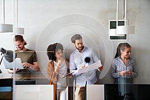 Group of young happy creative team, multicultural coworkers working in office together