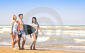 Group of young happy friends with surfboard at the beach