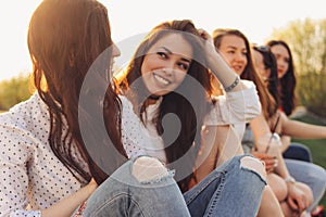 Group of young happy girls friends enjoy life on summer city street, sunset background