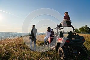 group young happy people enjoying beautiful sunny day while driving a off road buggy car