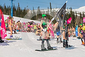 Group of young happy pretty women on a snowboard in colorful bikini with flags.