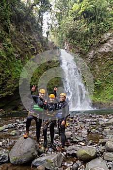 A group of young happy rock climbers in helmets and climbing equipment preparing for an adventure