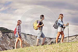 Group of young hikers in the mountain in single file