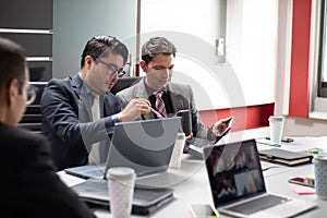 Group of young hispanic businessmen having meeting in conference room. Creative discussion business team using electronic devices