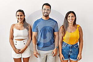 Group of young hispanic people standing over isolated background with a happy and cool smile on face