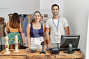 Group of young hispanic people working as manager at retail boutique looking positive and happy standing and smiling with a