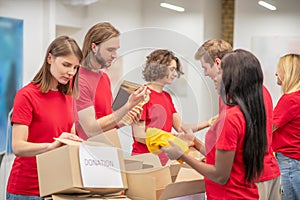 Group of young interested people packing donations