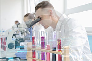 Group of young Laboratory scientists working at lab with test tubes and microscope, test or research in clinical laboratory.