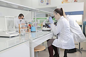 Group of young Laboratory scientists working at lab with test tubes and microscope, test or research in clinical laboratory.