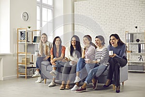 Group of young laughing positive women watching movie together