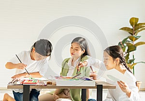 group of young and little children and teacher intend painting color in education classroom, focus at young child.