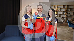 A group of young medical people in uniform stand in the middle of the classroom and smile after a first aid lesson