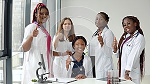 A group of young medics sitting and standing at a table show class