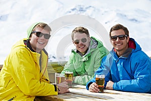 Group Of Young Men Enjoying Drink In Bar At Ski Resort