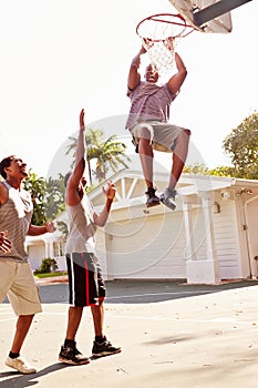 Group Of Young Men Playing Basketball Match