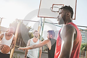 group of young multicultural men playing basketball