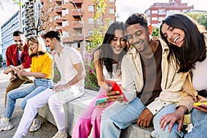 Group of young net generation friends having fun using cellphones outdoors