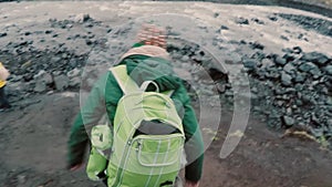 Group of young people with backpacks going to camping together. Friends walking through the rocks near the river.