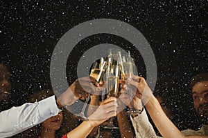 Group of young people celebrating new year with champagne at night club