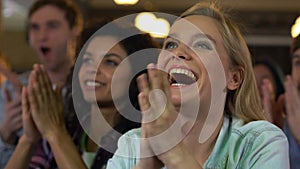 Group of young people clapping hands on music concert in pub, favorite band