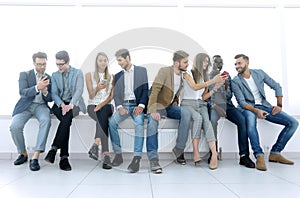 Group of young people communicate in the waiting room.