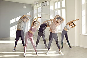 Group of young people doing exercise during a fitness workout with a sports instructor