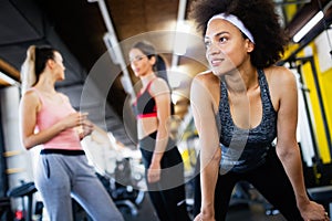 Group of young people doing exercises in fitness club