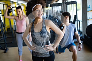 Group of young people doing exercises in fitness club