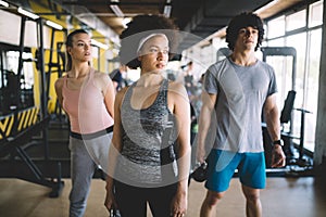 Group of young people doing exercises in fitness club