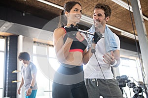 Group of young people doing exercises in fitness club